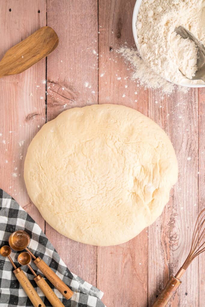 Dough turned out onto a floured surface after the first rise, ready to divide.