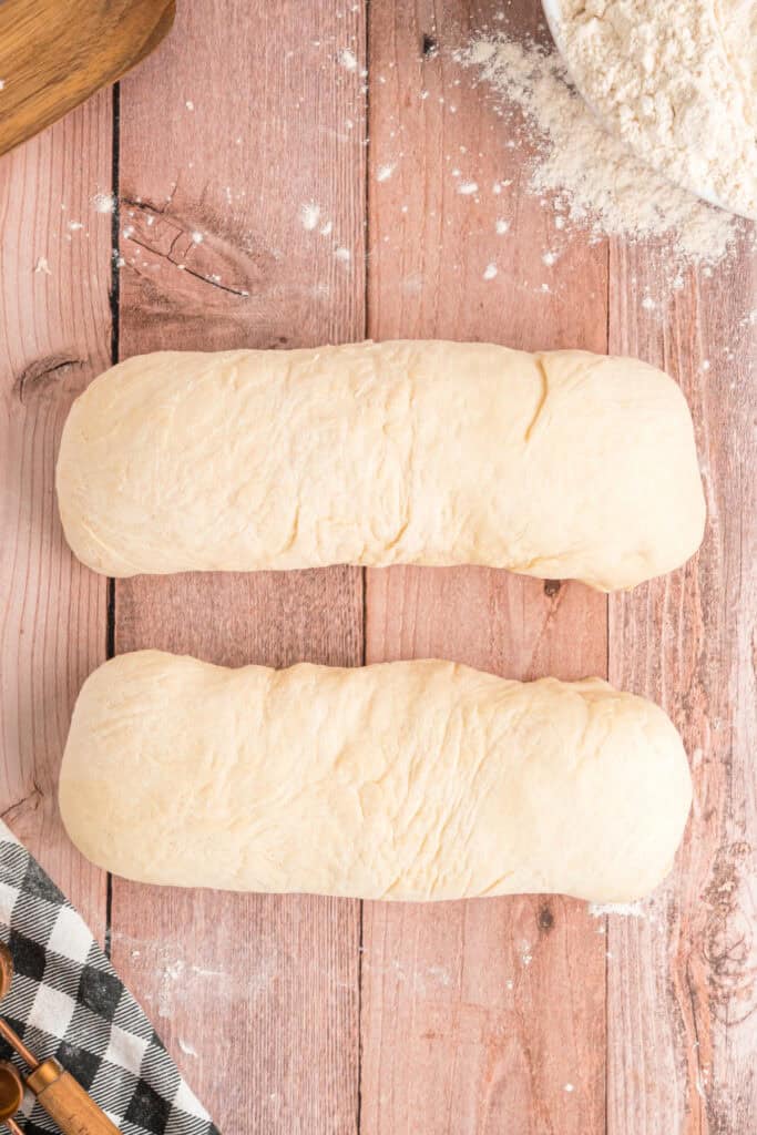 Two shaped loaves of dough ready to be placed into loaf pans for the second rise.