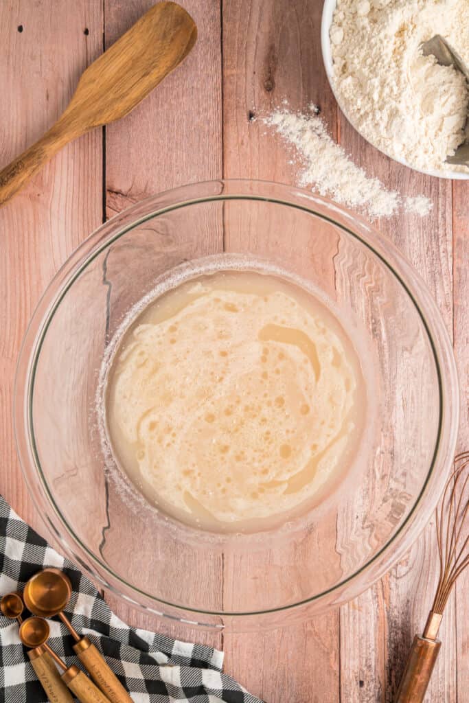 Foamy, activated yeast mixture after 5 minutes, ready for the next step in Amish bread prep.