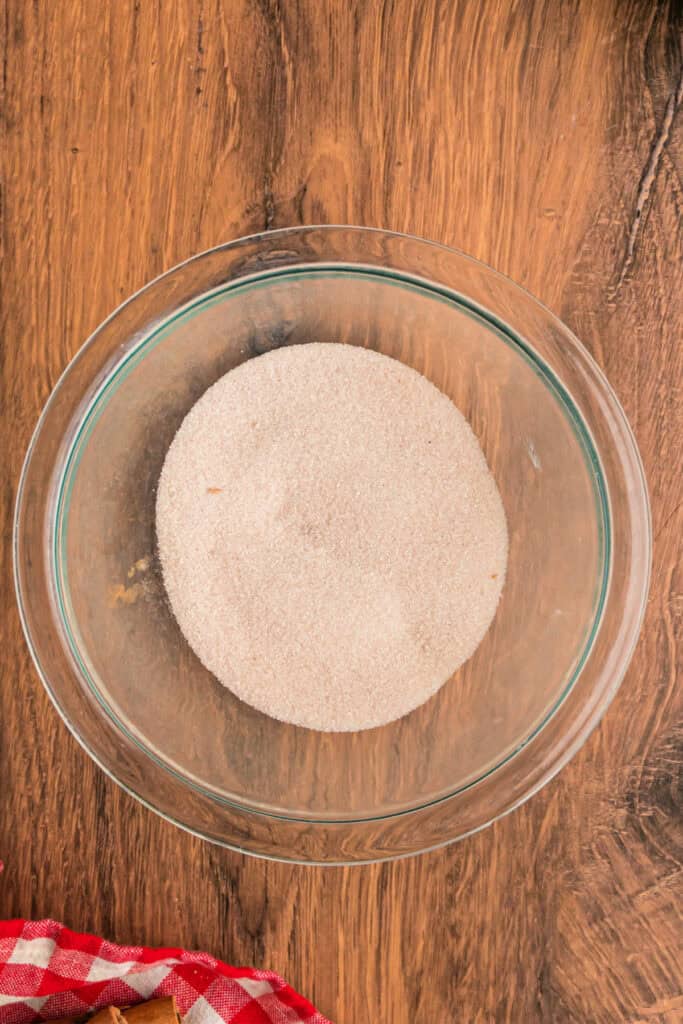 Cinnamon-sugar mixture fully blended in a glass bowl, ready to layer into the apple fritter bread.