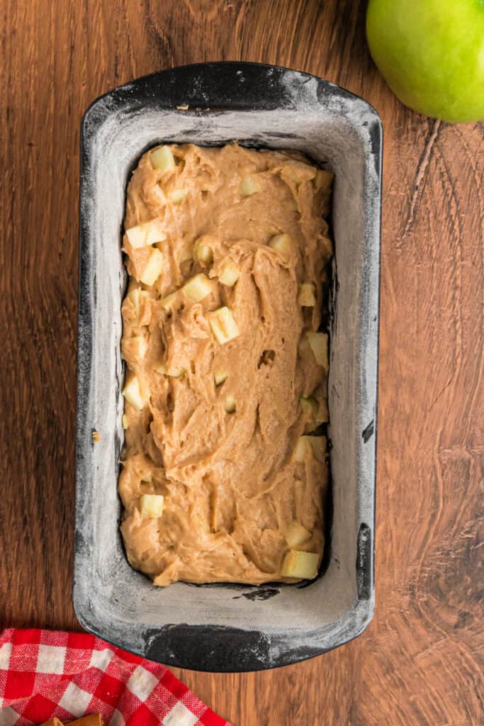 Loaf pan filled with apple fritter bread batter before adding the cinnamon-sugar swirl.