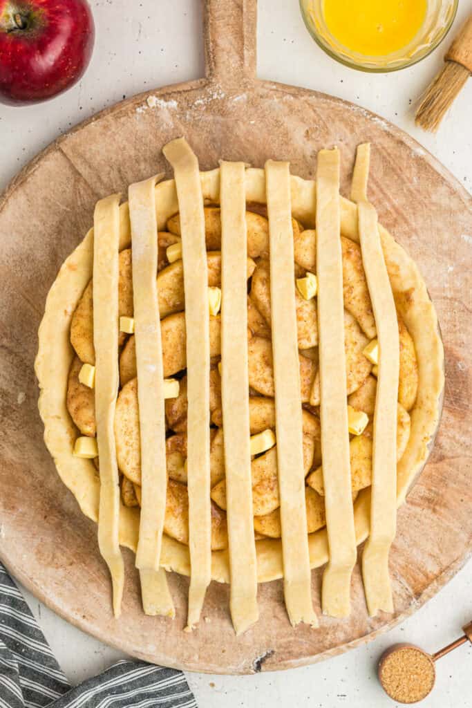 Partially assembled pie with vertical lattice strips placed over filling.