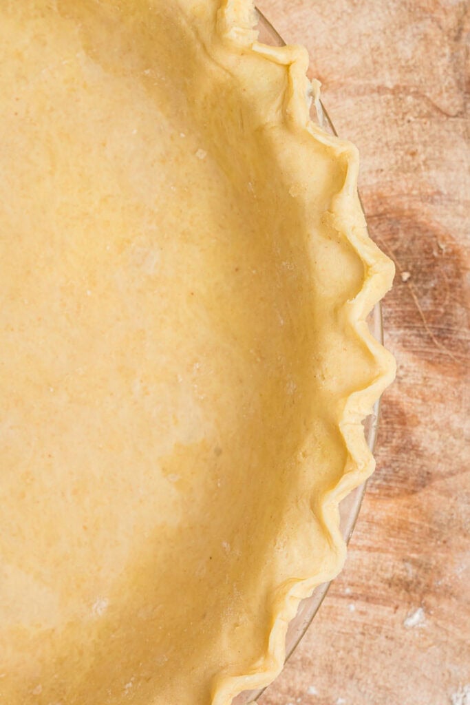 Close-up of fluted edge on butter pie crust pressed into a pie dish