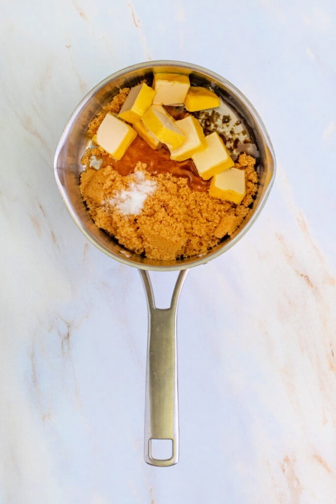 Saucepan with chunks of butter, brown sugar, salt, and corn syrup before cooking