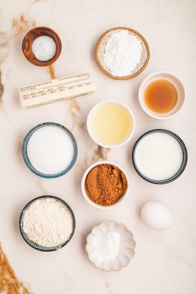 Overhead shot of ingredients for chocolate donut holes arranged on marble surface