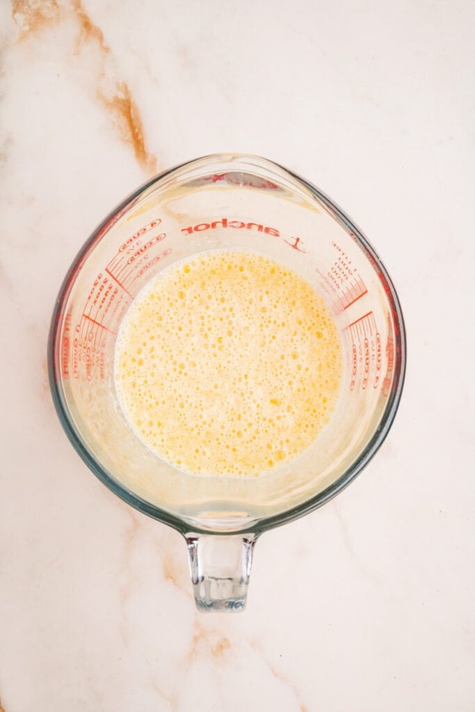 Wet ingredients whisked together in a measuring cup until frothy