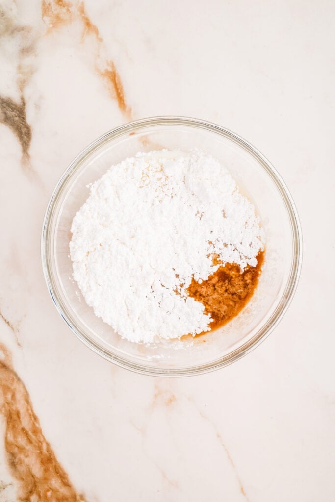 Glaze ingredients including powdered sugar and vanilla in a mixing bowl