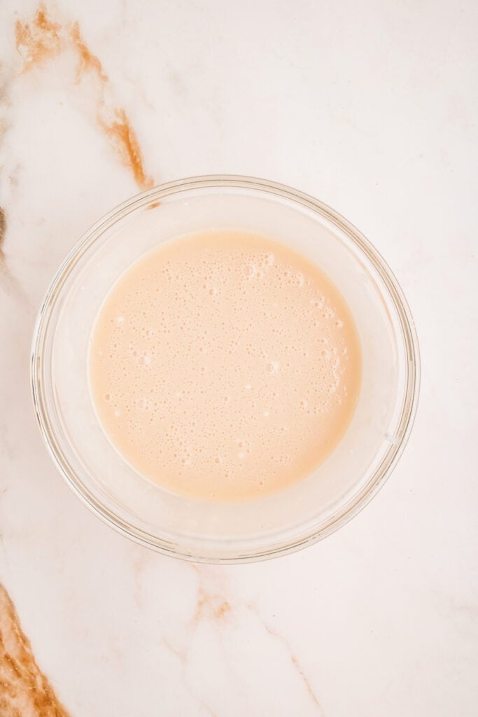 Smooth vanilla glaze mixed and ready in a glass bowl