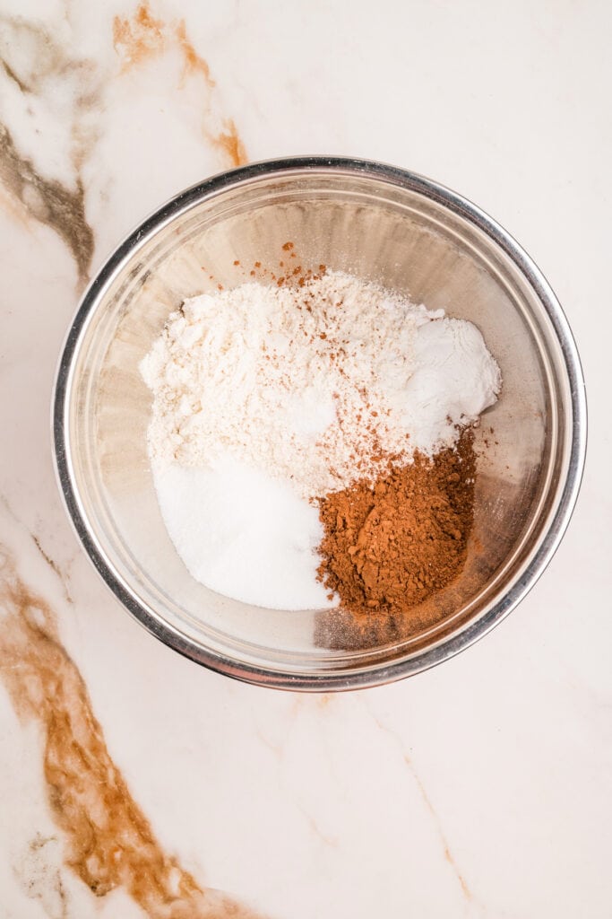 Dry ingredients for chocolate donut holes in a metal mixing bowl