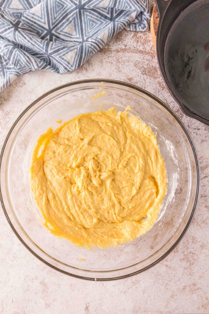 Mixing bowl filled with smooth sourdough cornbread batter, ready to be transferred to skillet.
