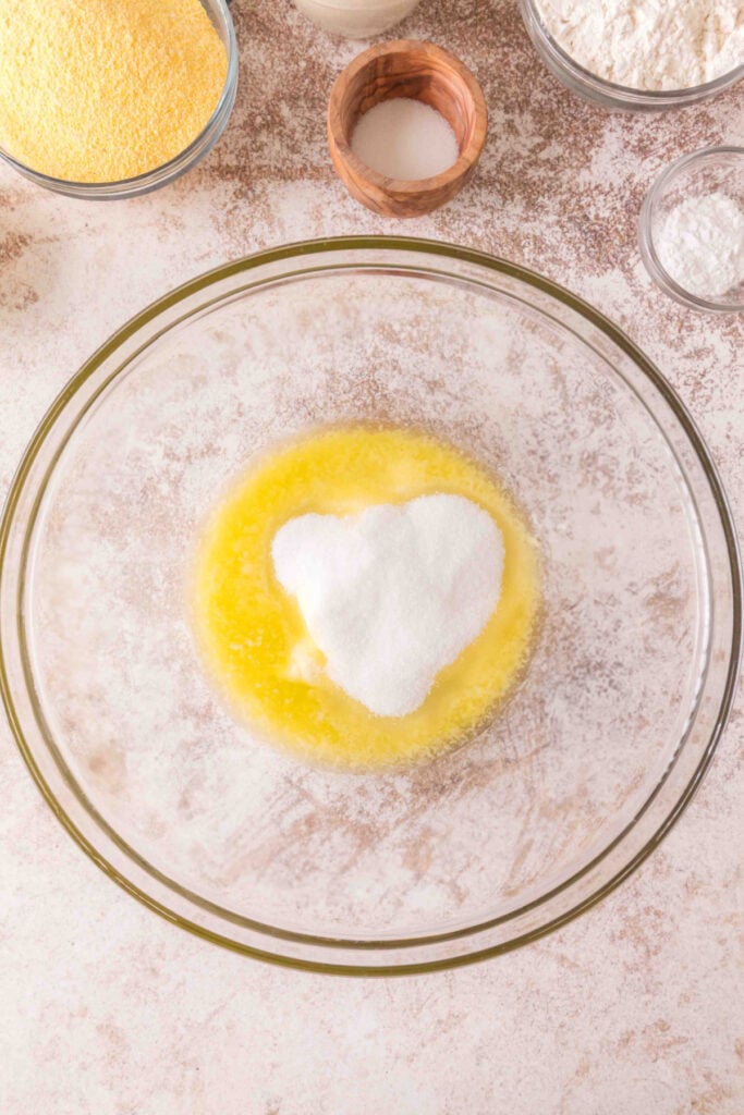 Bowl of melted butter with granulated sugar added on top, ready to be mixed.