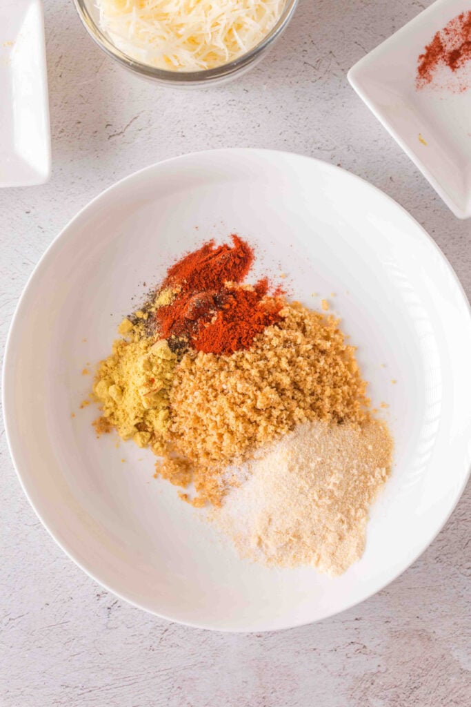 Mixing bowl with crushed croutons, spices, and seasonings for pork chop breading.
