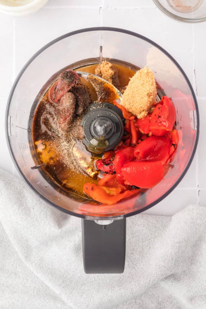 Ingredients for chipotle honey sauce placed inside a food processor bowl before blending.