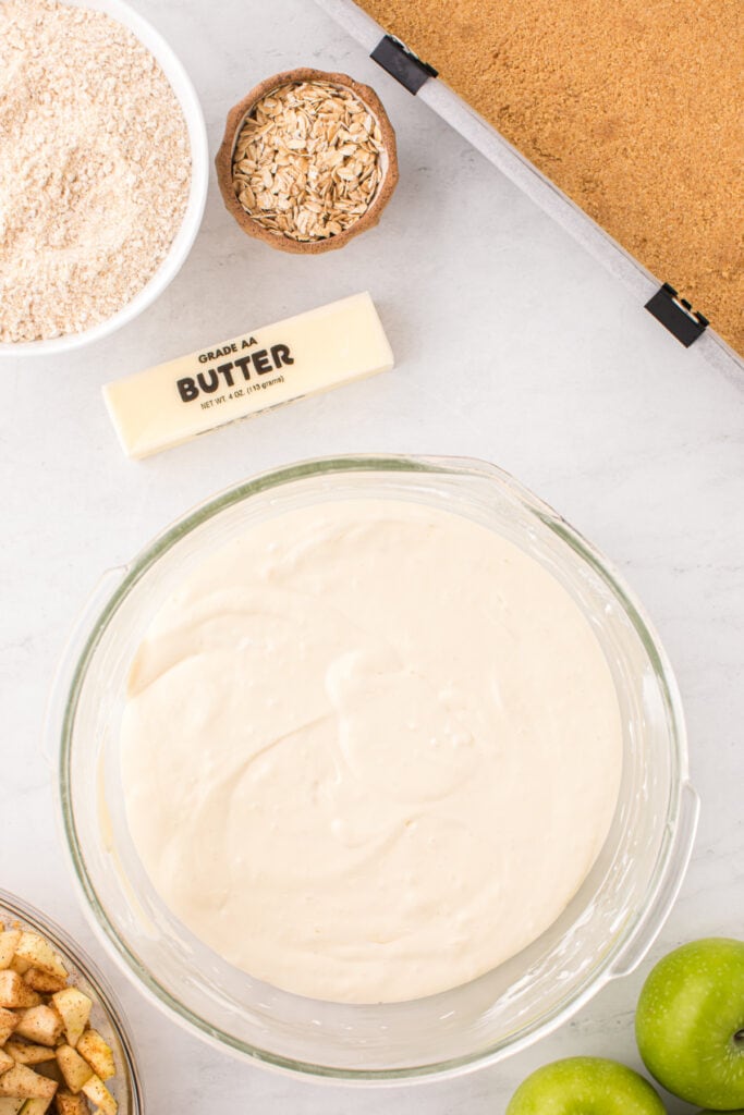 Smooth cheesecake batter in a glass bowl ready to be poured over crust.
