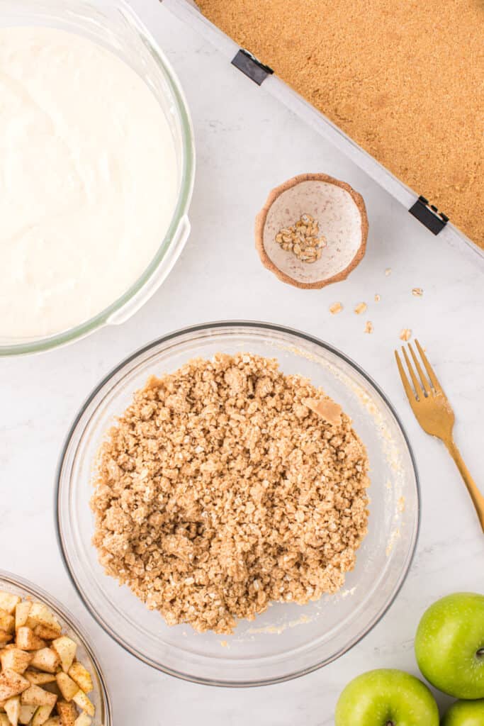 Crumb topping mixture in a glass bowl after mixing, ready to sprinkle over cheesecake.