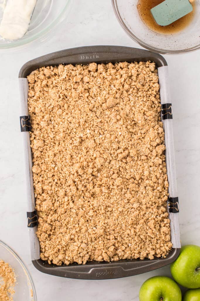 Pan filled with cheesecake and apple layers topped generously with crumb mixture.