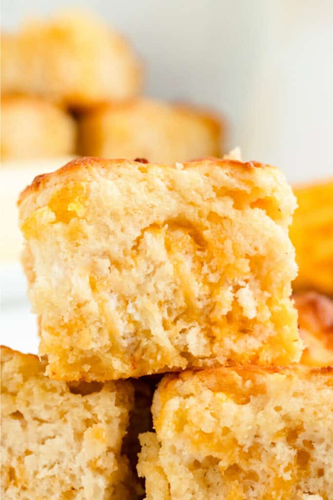 Stacked Cheddar Butter Swim Biscuits highlighting moist, cheesy inside and crisp golden edges.