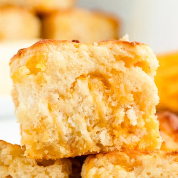 Close-up square crop of a Cheddar Butter Swim Biscuit with a golden top and cheesy center.