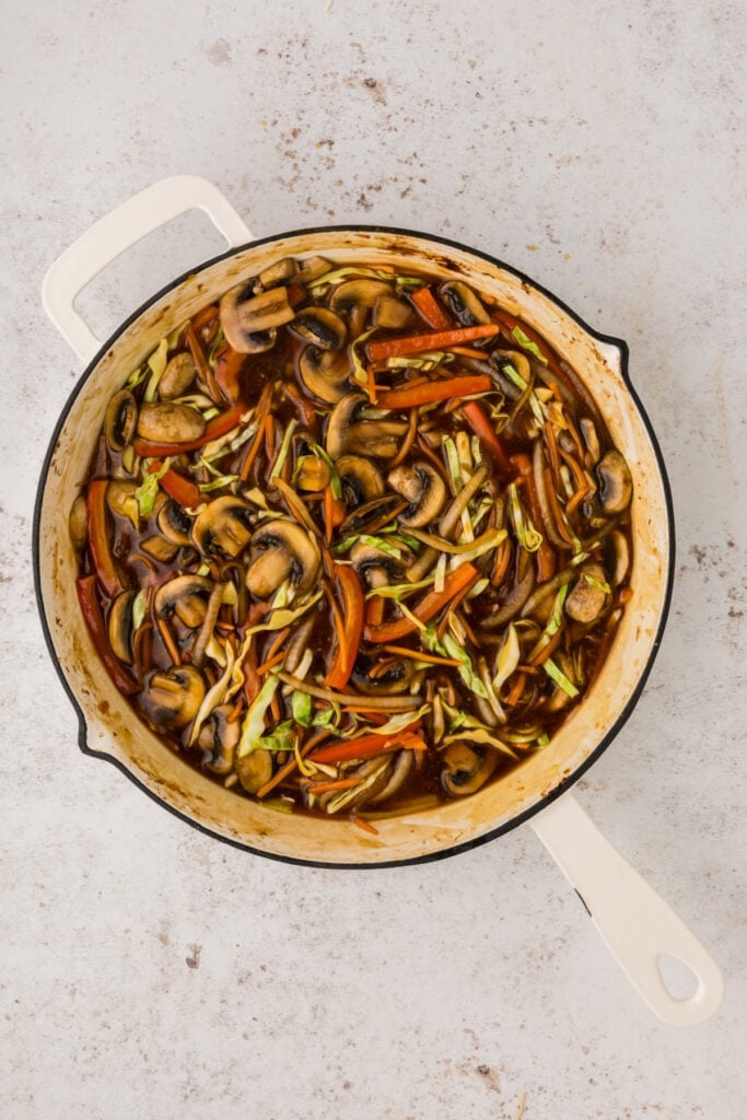 Vegetables simmering in thickened sauce inside a skillet
