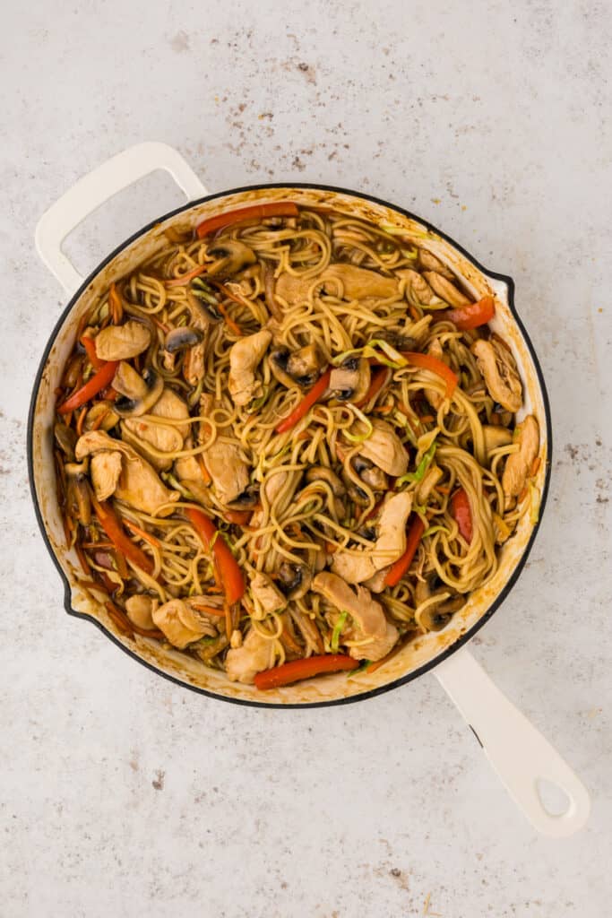 Chicken and vegetables mixed with lo mein noodles in a skillet