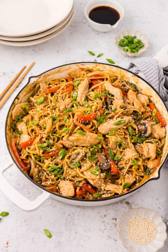 Finished Chicken Lo Mein in skillet garnished with sesame seeds and sliced green onions