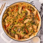 Square overhead image of Chicken Lo Mein in skillet topped with sesame seeds and green onions