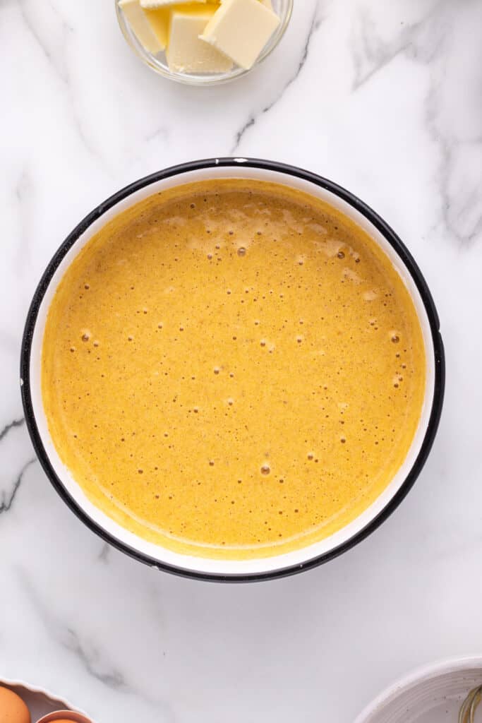 Smooth pumpkin roll batter mixed and ready for baking in a large bowl.