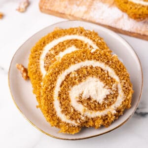 Overhead square image of pumpkin roll slices showing cream cheese swirls.