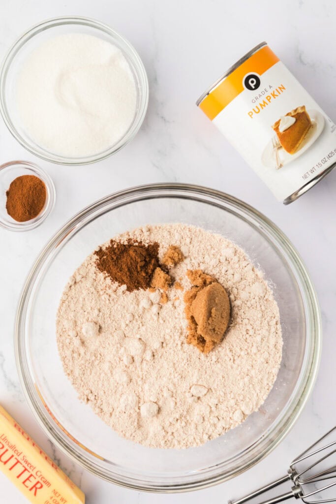 Mixing bowl with spice cake mix, pumpkin pie spice, and brown sugar ready to be combined for pumpkin spice donut holes.