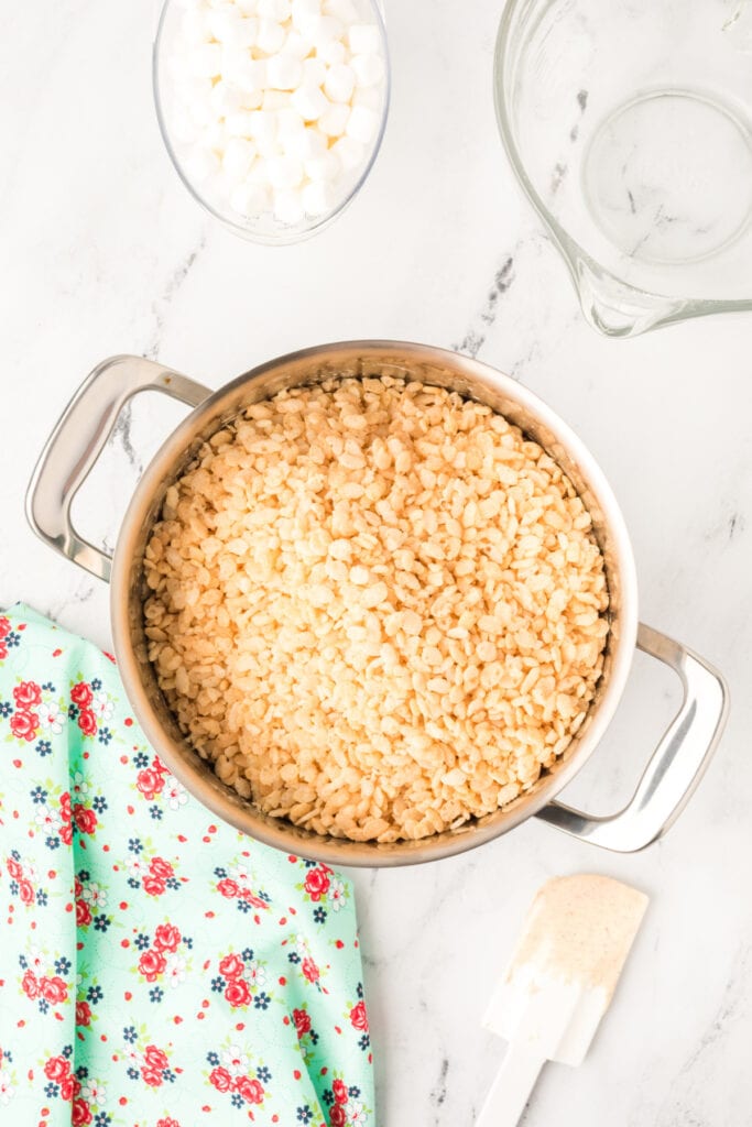 Crispy rice cereal poured into the pot of melted marshmallow and browned butter mixture.
