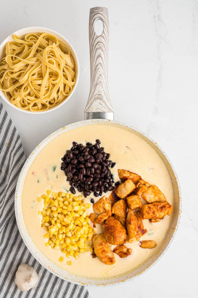 Cooked chicken, black beans, and corn added to the creamy sauce.