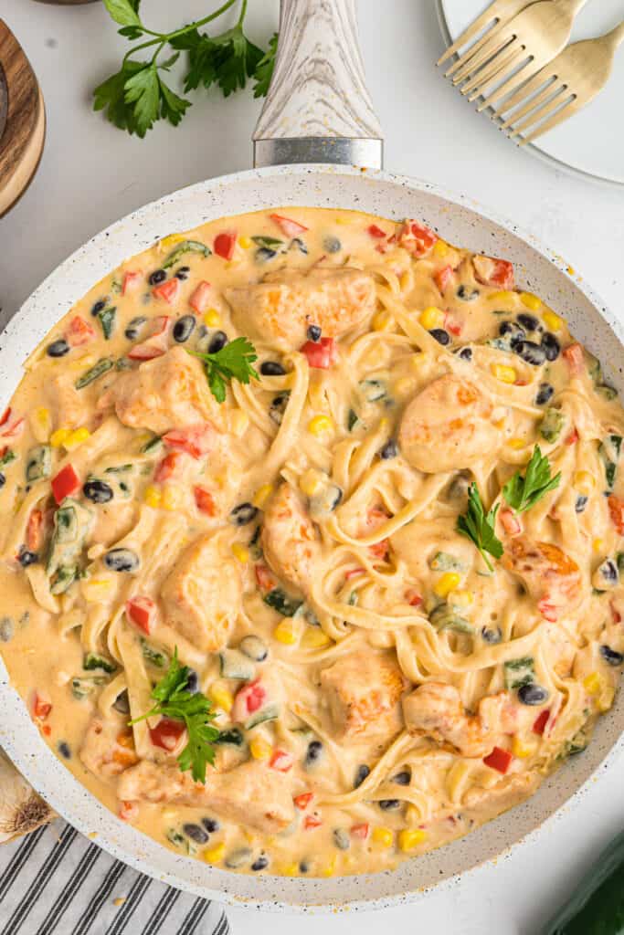 Close-up of creamy southwest chicken fettuccine alfredo with beans, corn, and peppers.