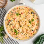 Overhead square crop of skillet filled with southwest chicken fettuccine alfredo, garnished with parsley.