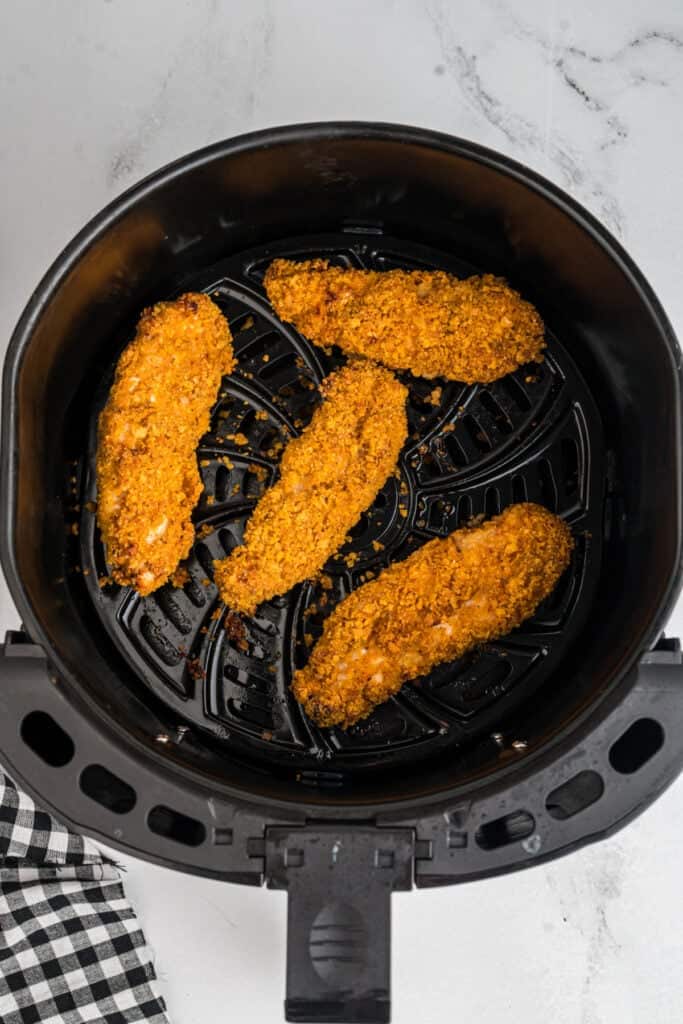 Crispy cooked southwest chicken tenders in the air fryer basket after cooking.