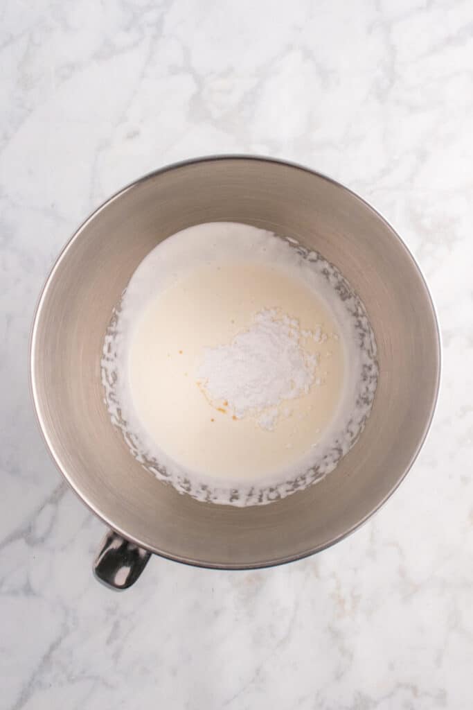 Mixing bowl of whipped cream with powdered sugar and vanilla added on top, ready to be blended for toxic waste foam.
