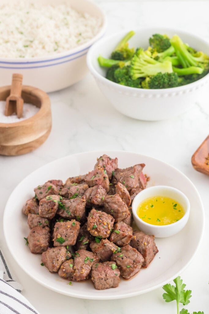 Air fryer steak bites served with rice and broccoli for a complete meal.