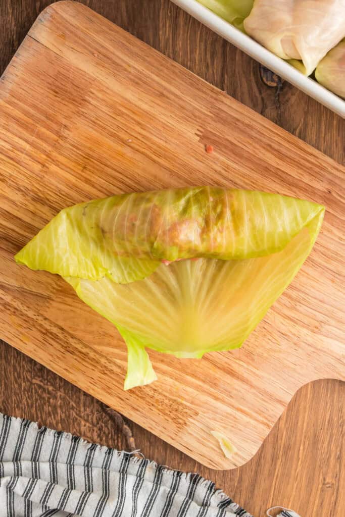 Cabbage leaf partially folded over the filling to start forming a cabbage roll.