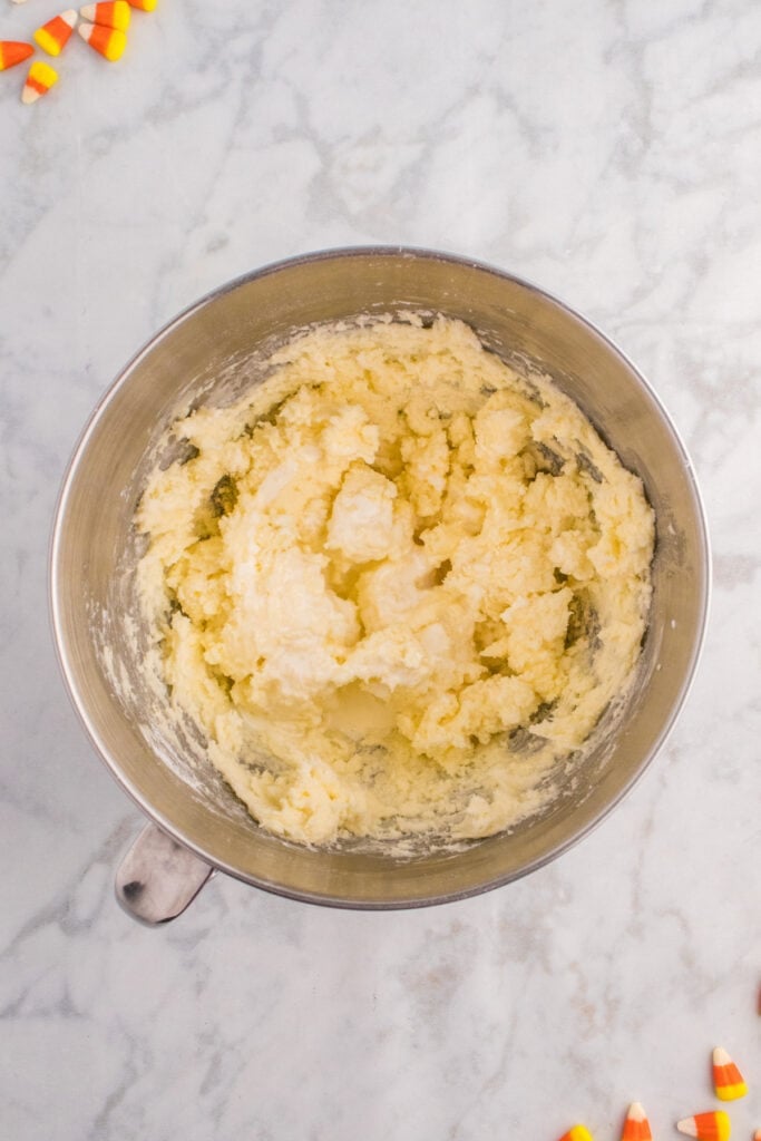 Frosting mixture in progress showing combined butter, cream, and vanilla partially mixed.