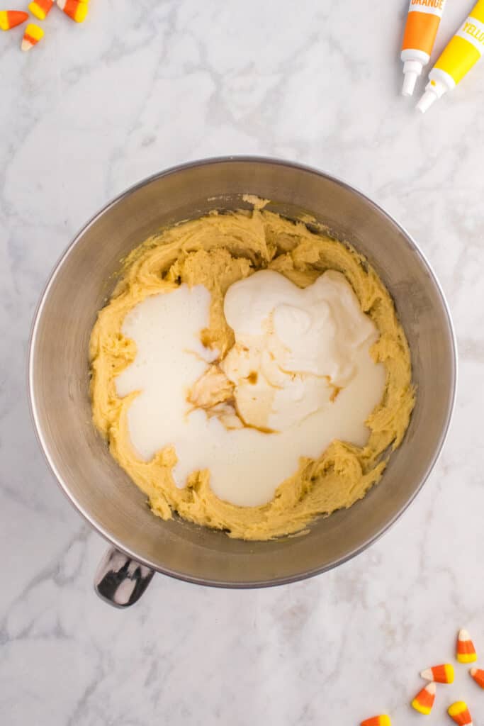 Batter in mixing bowl with Greek yogurt, buttermilk, and vanilla extract added on top before final mixing.