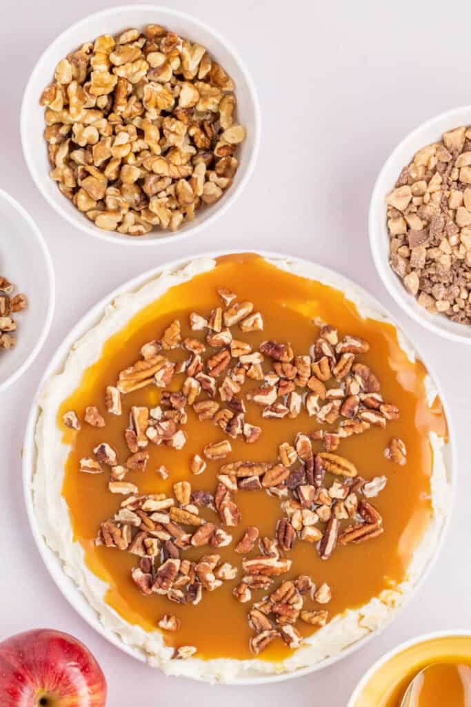Chopped pecans sprinkled over the caramel layer in the dessert dish.