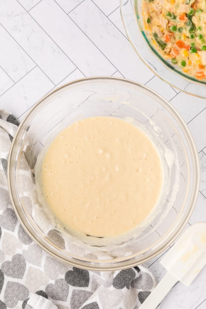 Smooth biscuit batter in a glass bowl ready to be spread over the chicken filling.