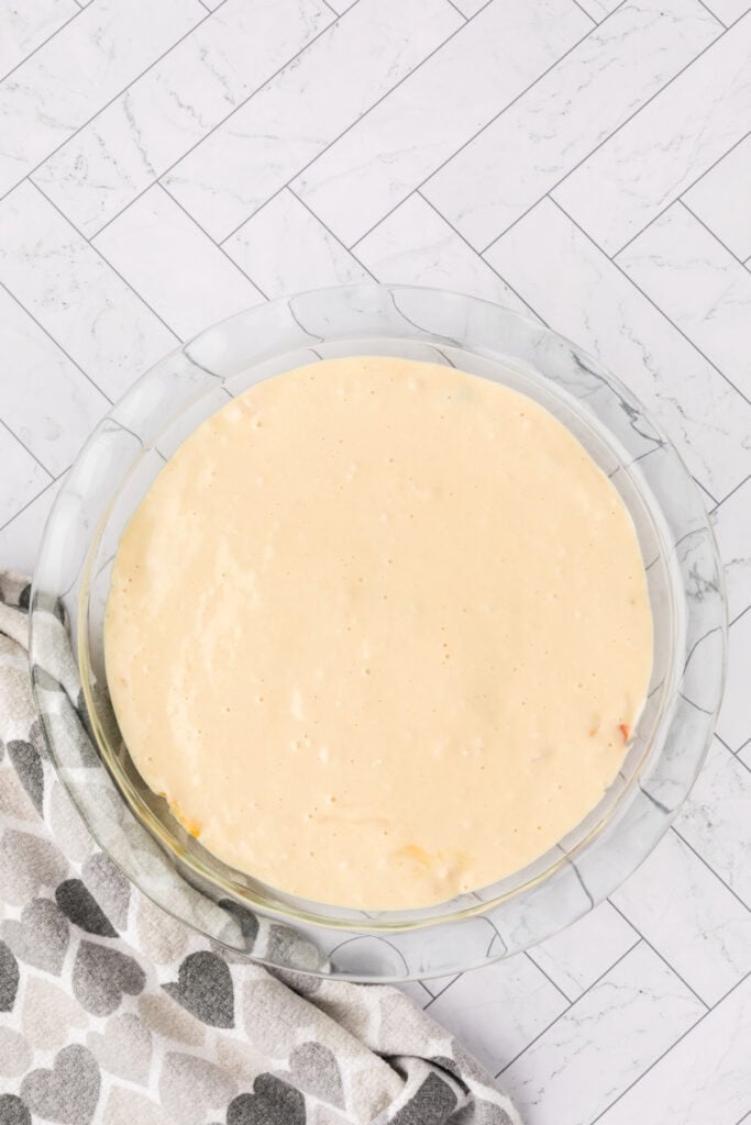 Biscuit topping spread evenly over the chicken and vegetable filling in a pie dish.