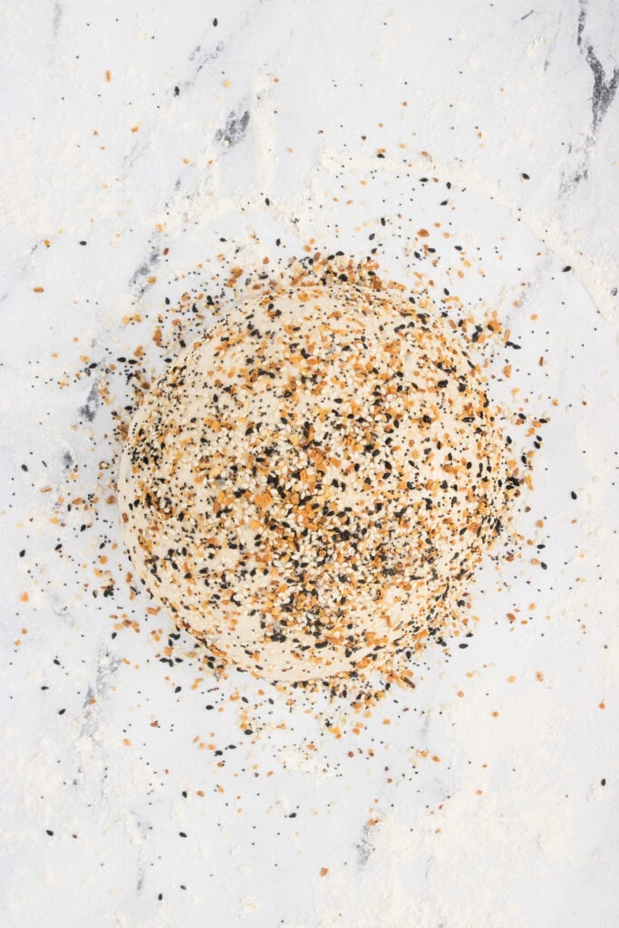 Shaped loaf coated with everything bagel seasoning before baking.