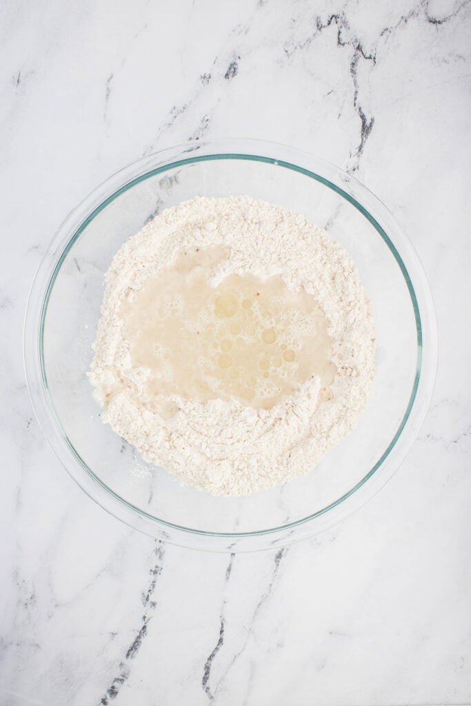 Well created in the center of dry ingredients filled with water and olive oil.