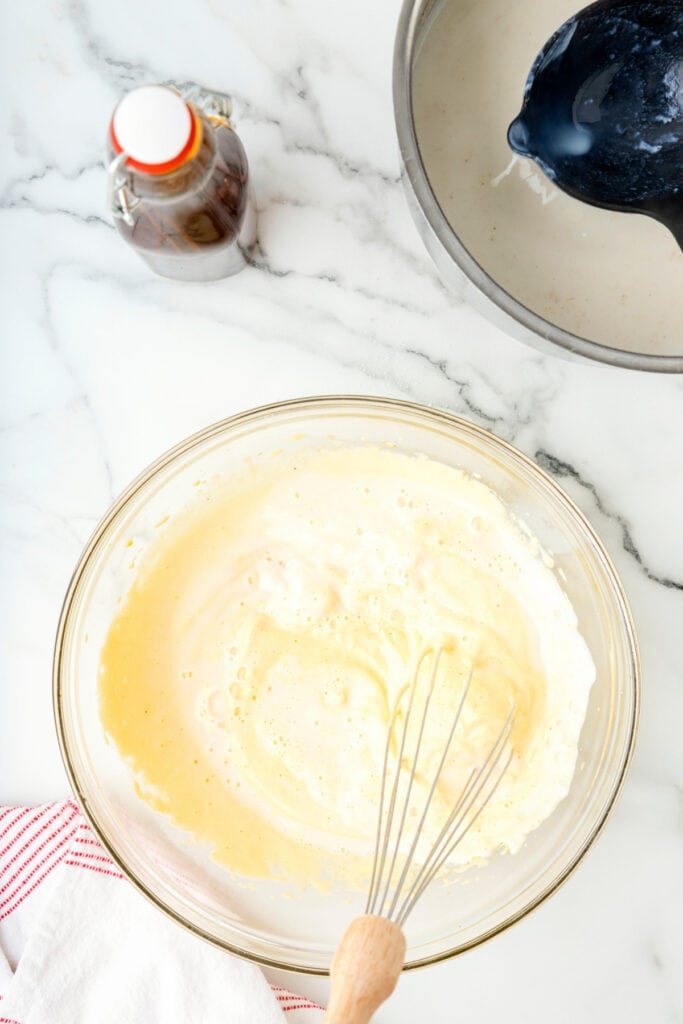 Eggnog mixture in a glass bowl after combining milk and egg yolks, ready to cook further.