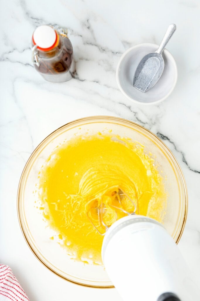 Egg yolks and sugar whipped until pale and fluffy with an electric mixer in a glass bowl.
