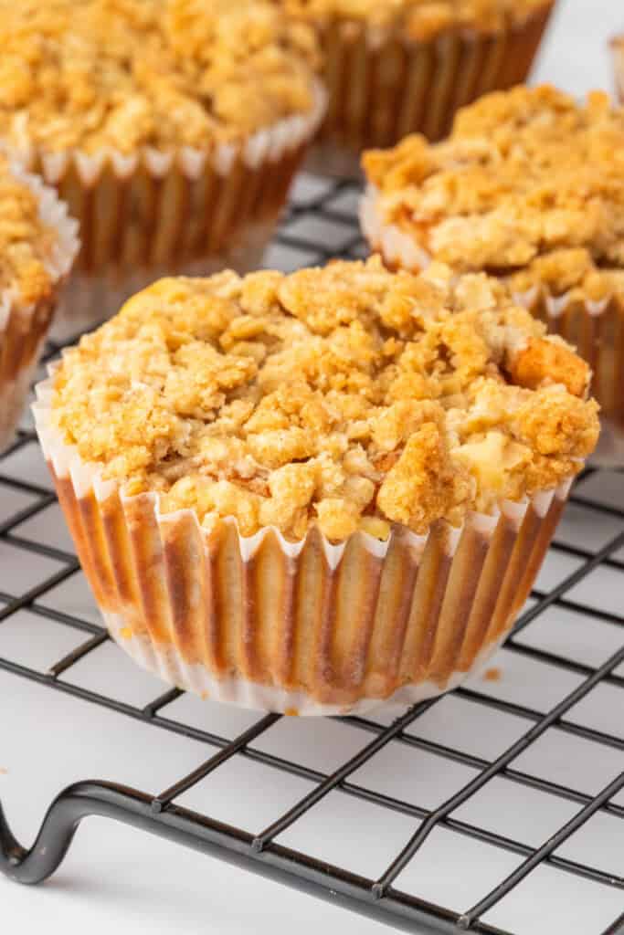 Close-up of a single Mini Apple Crumble Cheesecake on a cooling rack showing the crumbly oat topping.