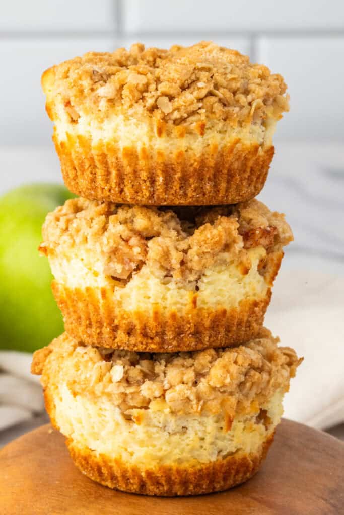 Stack of three Mini Apple Crumble Cheesecakes showing the creamy cheesecake center and golden crust.