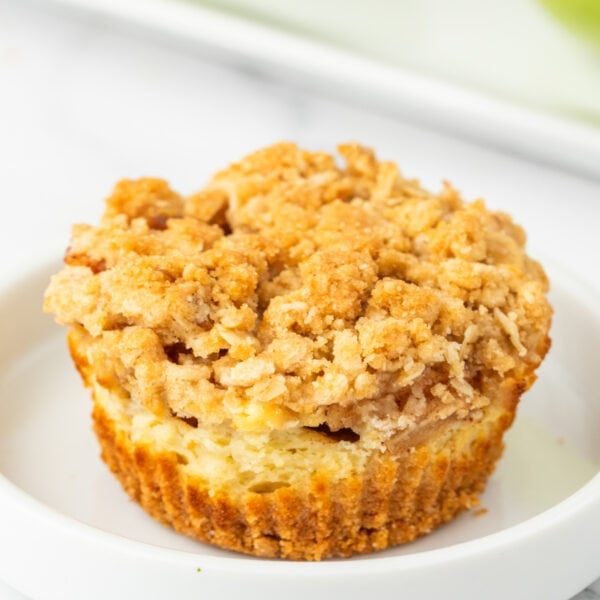 Square crop of a golden Mini Apple Crumble Cheesecake with crumbly oat topping and visible apple pieces.