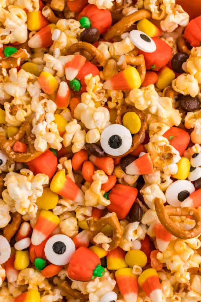 Close-up of Monster Mash Popcorn showing details of popcorn, candy eyeballs, pretzels, candy corn, and pumpkins.